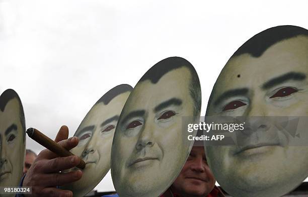 Man holds a cigar to the mouth of a mask depicting British Airways chief executive Willie Walsh during a strike by British Airways cabin crew members...