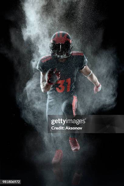 american football player in a haze on black background - football uniform stock pictures, royalty-free photos & images