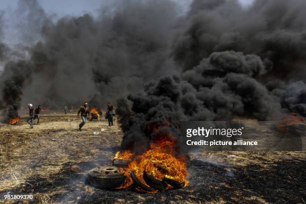 Palestinian protesters burn tires during clashes with Israeli forces along the Israeli-Gaza border in Khan Younis, central Gaza Strip, 06 April 2018....