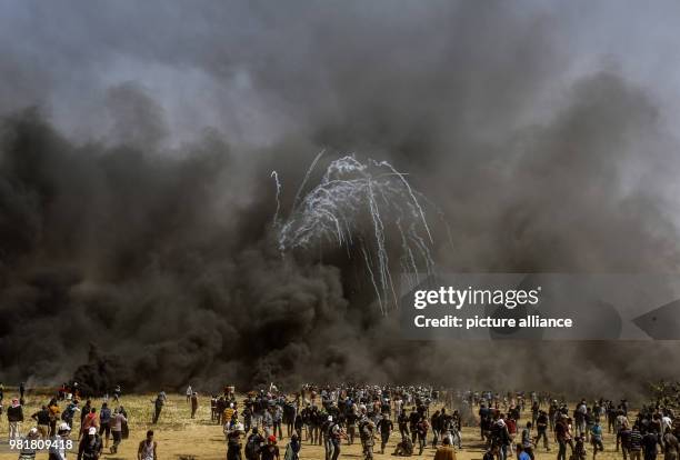 Palestinian protesters run for cover as Israeli forces shot teargas grenades during clashes along the Israeli-Gaza border in Khan Younis, central...