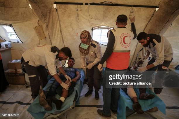 Injured Palestinian protestors receive treatment at a medical tent during clashes with Israeli Security Forces along the Israel-Gaza border in...