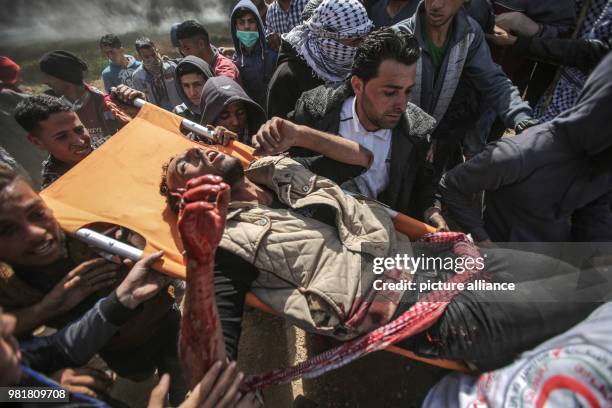 Palestinian protesters carry an injured man during clashes with Israeli Security Forces along the Israel-Gaza border in Jabalia, Gaza Strip, 06 April...