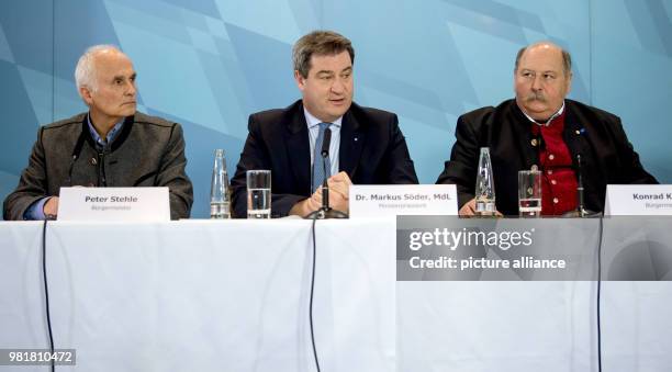 April 2018, Germany, Munich: Peter Stehle , mayor of Obermaiselstein, Bavarian Minister President Markus Soeder and Konrad Kienle , mayor of...