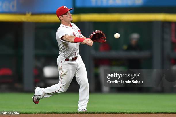 Scooter Gennett of the Cincinnati Reds fields a ground ball and throws to first base against the Detroit Tigers at Great American Ball Park on June...