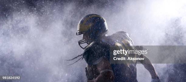 american football speler in een waas op zwarte achtergrond. portret - aksonov stockfoto's en -beelden