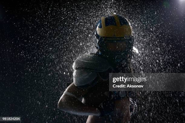 american football player in a water drops on black background. portrait - aksonov stock pictures, royalty-free photos & images