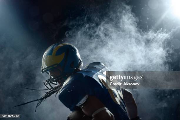 american football speler in een waas op zwarte achtergrond. portret - aksonov stockfoto's en -beelden