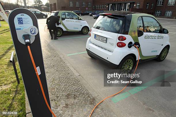 An employee of German engineering company Siemens, at the request of the photographer, demonstrates how to attach the charging cable from a...