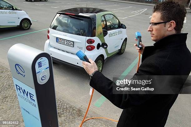 An employee of German engineering company Siemens, at the request of the photographer, demonstrates how to attach the charging cable from a...