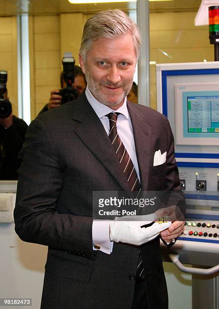 Prince Philippe of Belgium poses with a 100 euro coin at Belgiums Royal Mint on April 1, 2010 in Brussels, Belgium. The golden 100 euro coin with a...
