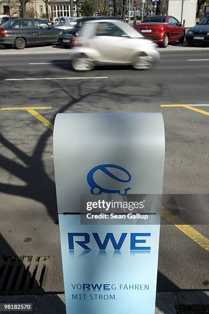 Car drives past a sidewalk-mounted electric car charger on April 1, 2010 in Berlin, Germany. German power producer RWE has erected and is operating...