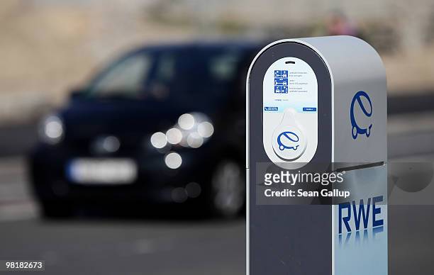 Car drives past a sidewalk-mounted electric car charger on April 1, 2010 in Berlin, Germany. German power producer RWE has erected and is operating...