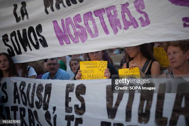 Woman behind a large banner holds a placard with the slogan, Calms sister, this is your pack, as she takes part in the protest. A demonstration...