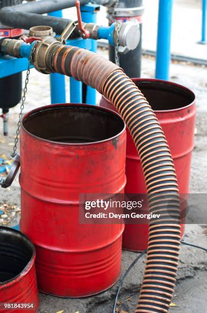 truck hoses for fuel station, pumps and oil barrels - drum container stock-fotos und bilder