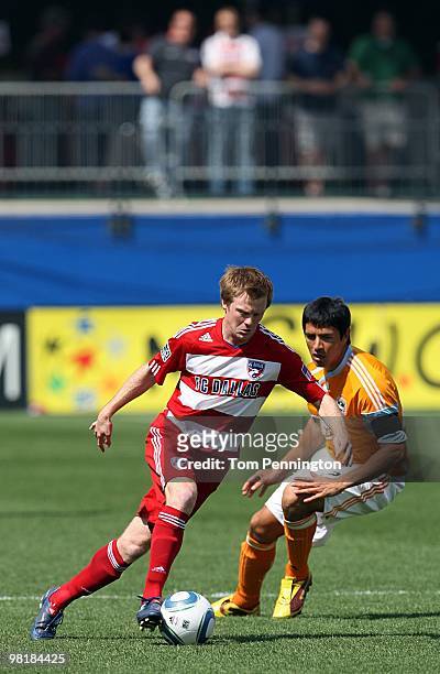 Midfielder Dax McCarty of FC Dallas controls the ball against forward Brian Ching of the Houston Dynamo during a MLS game at Pizza Hut Park on March...
