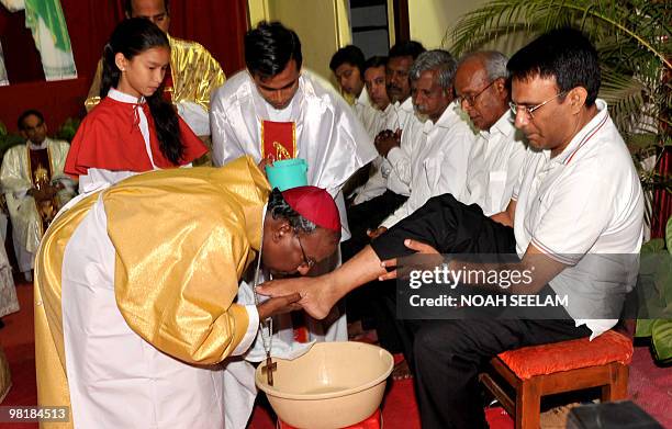 Indian Catholic Bishop of the Archdioecese of Hyderabad,Reverend M. Joji kisses the feet of a parishioner during the evening mass of the Lord Supper...