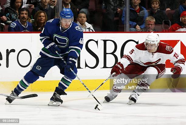 Michael Grabner of the Vancouver Canucks and Matthew Lombardi of the Phoenix Coyotes battle for the puck during the game at General Motors Place on...