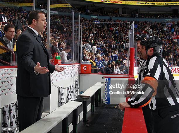 Head coach Alain Vigneault of the Vancouver Canucks talks to referee Bill McCreary during the game against the Phoenix Coyotes at General Motors...