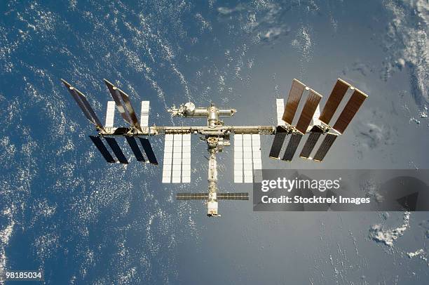 international space station backdropped against earth. - international space station stock-fotos und bilder