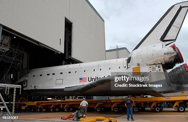 space shuttle atlantis rolls out of orbiter processing facility 1 at kennedy space center. - montagehalle stock-fotos und bilder