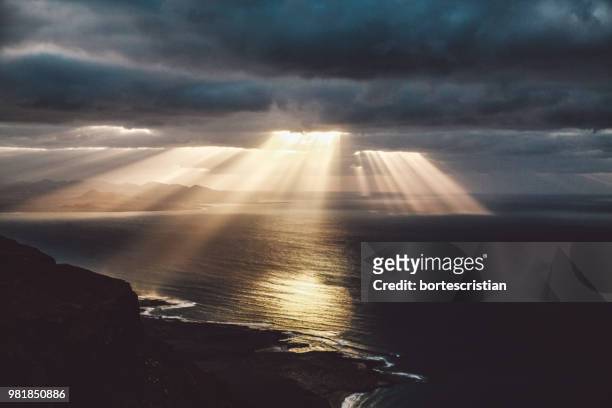 scenic view of sea against cloudy sky during sunset - bortes fotografías e imágenes de stock