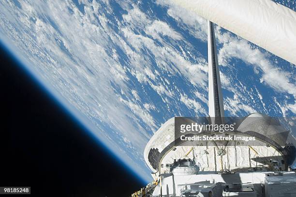 partial view of space shuttle endeavour backdropped against earth. - planeta terra fotografías e imágenes de stock