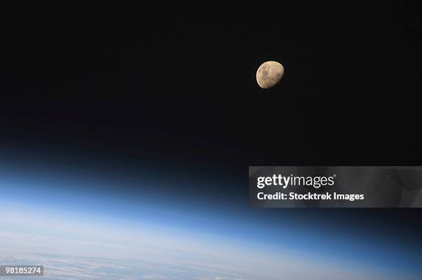 august 30, 2009 - a gibbous moon visible above earth's atmosphere. - airglow imagens e fotografias de stock