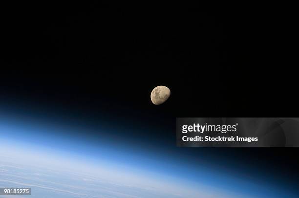 august 30, 2009 - a gibbous moon visible above earth's atmosphere. - airglow imagens e fotografias de stock