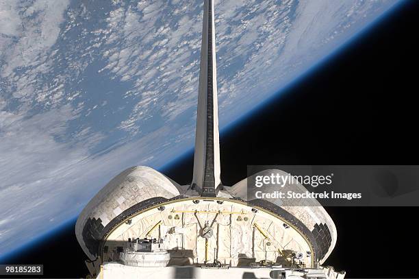 a partial view of space shuttle endeavour backdropped by earth's horizon. - planeta terra fotografías e imágenes de stock