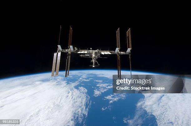 international space station backdropped by earth's horizon. - estação espacial internacional - fotografias e filmes do acervo