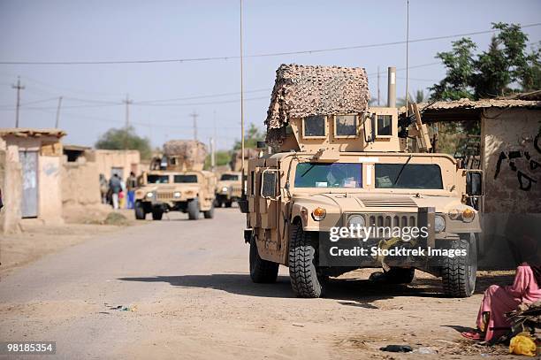 humvee's conduct security during a patrol in the village of abo atei. - civilian humvee stock pictures, royalty-free photos & images