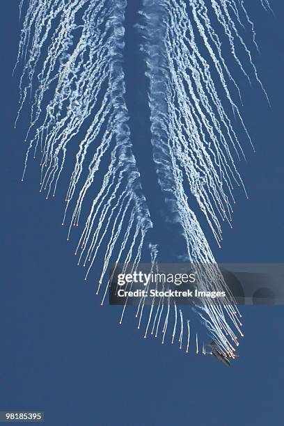 a u.s. air force ac-130 gunship aircraft executing an evasive maneuver and dropping chaff and flares - ac 130 gunship stockfoto's en -beelden