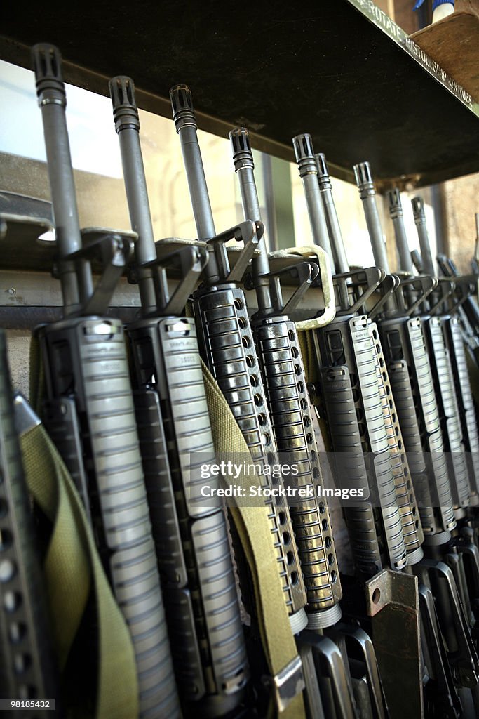 Assault rifles stand ready on the weapons rack.