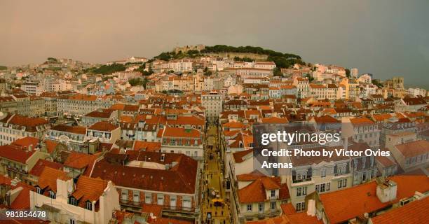 wide angle aerial view of downtown lisbon (baixa) at sunset. in the background, from left to right: graça, mouraria, saint jorge castle and cathedral - baixa quarter stock pictures, royalty-free photos & images