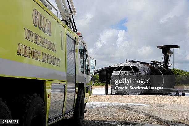 guam's wonpat airport practices putting out a fire on the aircraft fire trainer. - feuerwehr-hinweisschild stock-fotos und bilder