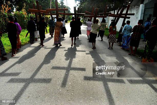 Roman Catholic devotees carry crucifixes along the main road of the East Timor capital Dili to mark Palm Sunday on March 28, 2010. Palm Sunday marks...