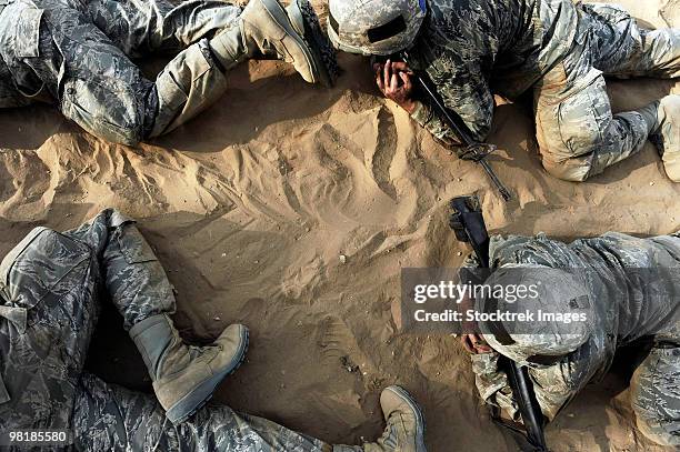 high angle view of basic trainees crawling through a tactical course. - boots rifle helmet stock-fotos und bilder