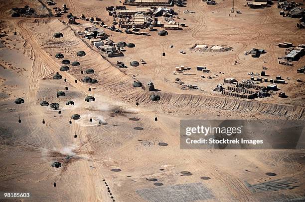 container delivery system bundles dropping from a c-17 globemaster iii in afghanistan. - basis stockfoto's en -beelden