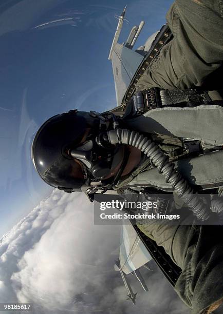 u.s. air force pilot turning sideways in an f-16 fighting falcon aircraft. - military man stock pictures, royalty-free photos & images