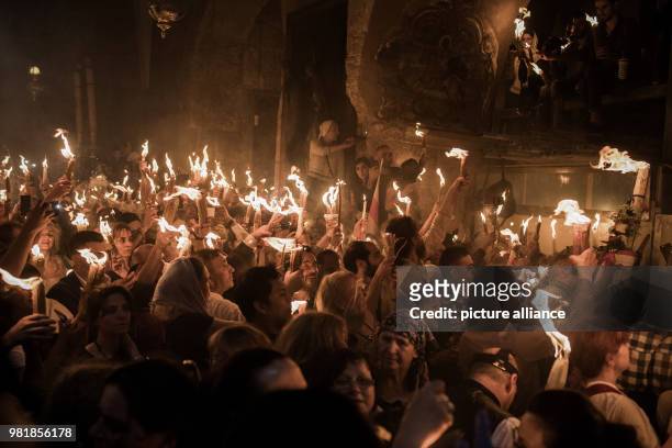 Christian Orthodox worshipers hold candles lit from a flame that emerged from the tomb believed to be the burial place of Jesus Christ, during the...
