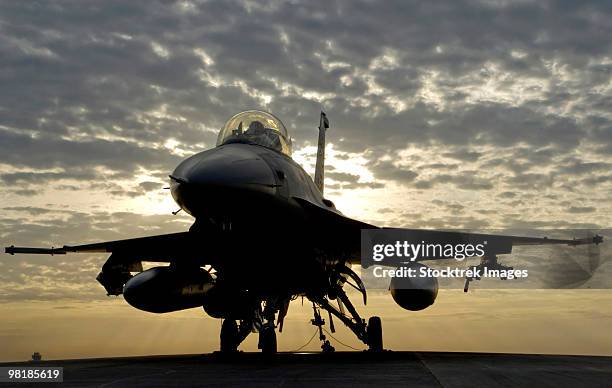 an f-16 fighting falcon sits tethered to the hot cargo pad at joint base balad, iraq. - f 16 fighting falcon stock pictures, royalty-free photos & images