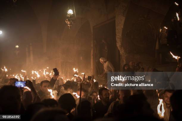Christian Orthodox worshipers hold candles lit from a flame that emerged from the tomb believed to be the burial place of Jesus Christ, during the...