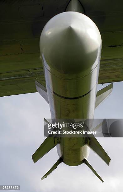 a harpoon missile attached to the wing of a p-3 orion. - arpón fotografías e imágenes de stock