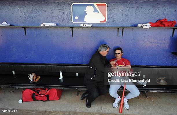 Manager Tony La Russa of the St. Louis Cardinals talks with St. Louis broadcaster Mike Shannon in the dugout before a Spring Training game against...