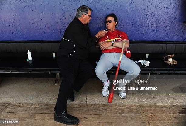 Manager Tony La Russa of the St. Louis Cardinals talks with St. Louis broadcaster Mike Shannon in the dugout before a Spring Training game against...