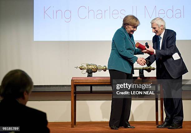 German Chancellor Angela Merkel is presented with the King Charles II Medal by Lord Martin Rees, President of the Royal Society and Master of Trinity...