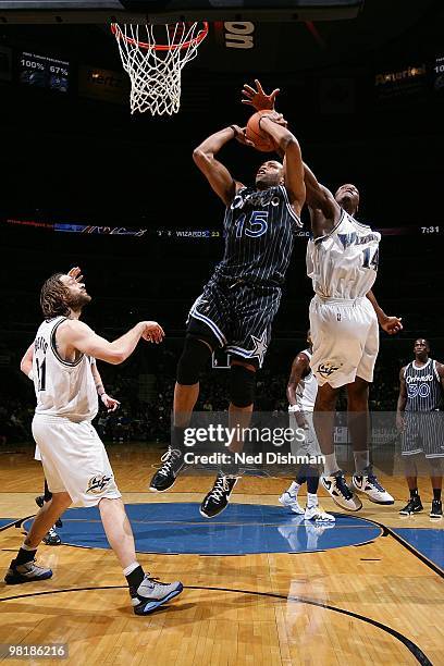 Vince Carter of the Orlando Magic goes to the basket against Al Thornton and Fabricio Oberto of the Washington Wizards during the game on March 13,...