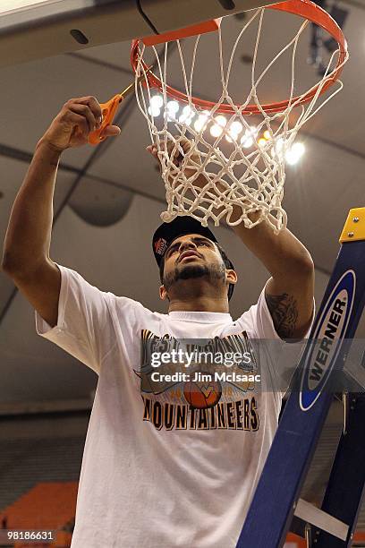 Casey Mitchell of the West Virginia Mountaineers cuts down a piece of the net following West Virginia's 73-66 win against the Kentucky Wildcats...