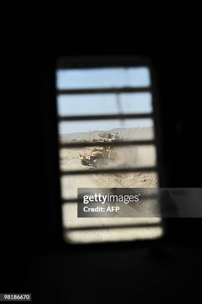Military vehicle is seen through the barred window of another during a patrol in Sar Hawza district of Paktika province on March 31, 2010. A bomb...