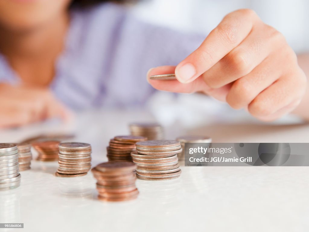Hispanic girl stacking coins